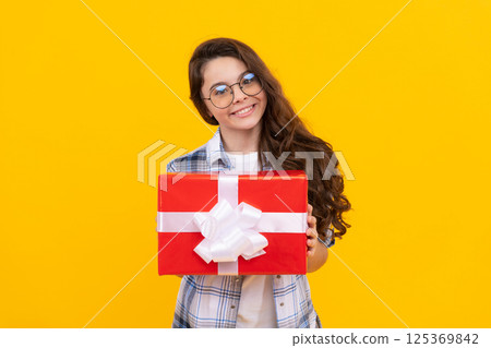 cheerful teen girl in glasses with present. studio shot of teen girl hold present. teen girl 125369842