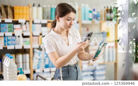 Young woman scanning qr code of toothbrush 125369946