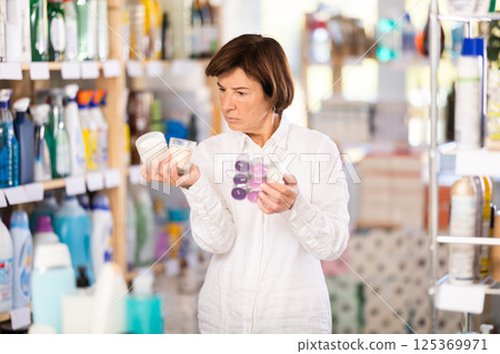 Elderly woman choosing scented candles in store 125369971
