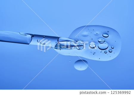 Serum with peptides on a blue background with a pipette. The texture. Serum with peptides on a blue background with a pipette. The texture. 125369992