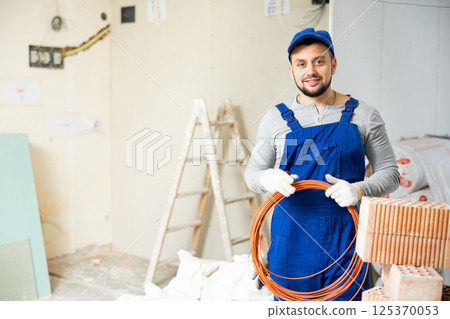 Positive foreman posing on indoor construction site Positive foreman posing on indoor construction site 125370053