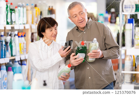 Couple man and woman scanning qr code for dishwashing detergent Couple man and woman scanning qr code for dishwashing detergent 125370076
