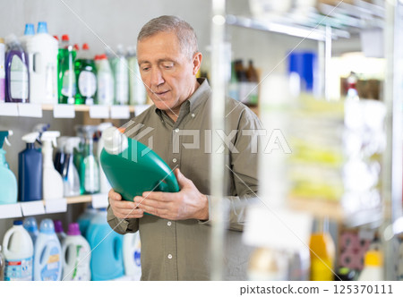 Male consumer with household chemical products for washing indoors 125370111