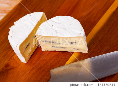 Slices of soft blue cheese on cutting board Slices of soft blue cheese on cutting board 125370234