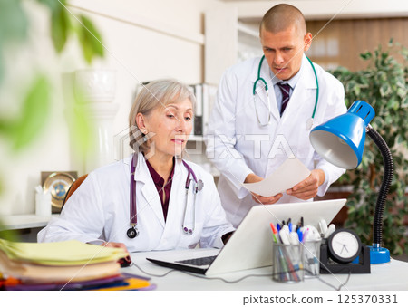 Male and female doctors in staffroom 125370331