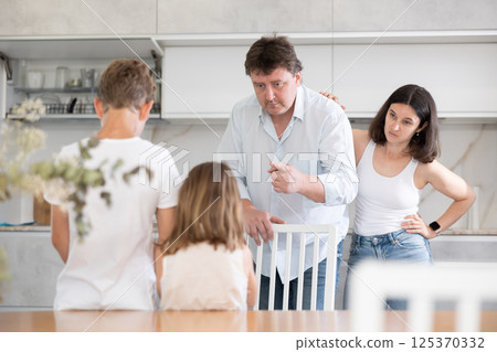 Parents scold their children in kitchen at home 125370332
