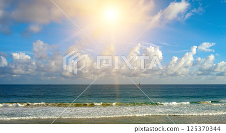 Bright sunrise over ocean waves. 125370344