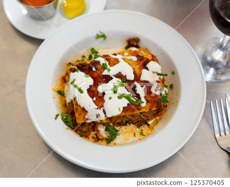 Dish of Italian cuisine is meat lasagna with delicious Parmesan cheese melted on top Dish of Italian cuisine is meat lasagna with delicious Parmesan cheese melted on top 125370405