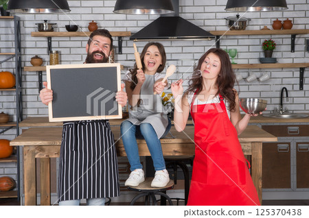 Family little daughter chalkboard recipe copy space at kitchen, help cooking concept 125370438