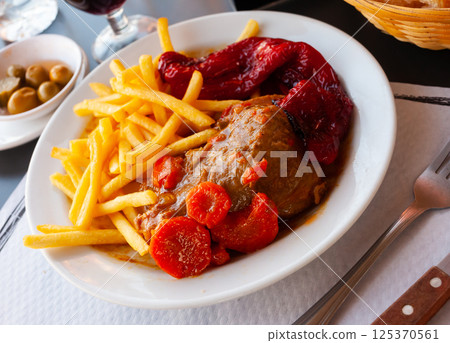 Stewed pork cheeks with baked red pepper and fries Stewed pork cheeks with baked red pepper and fries 125370561