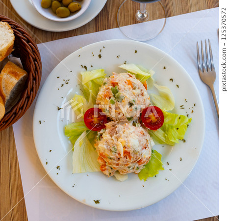 Appetizing Olivier salad with eggs, greens, vegetables, lettuce. Spanish cuisine 125370572