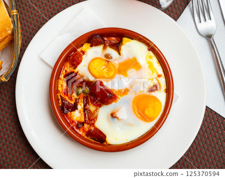 Popular spanish dish is fried eggs with chistorra 125370594