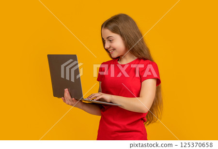 smiling child with laptop on yellow background smiling child with laptop on yellow background 125370658