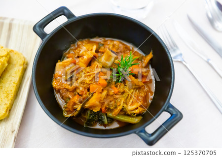 Cassoula with polenta. Meat on bone with stewed vegetables 125370705