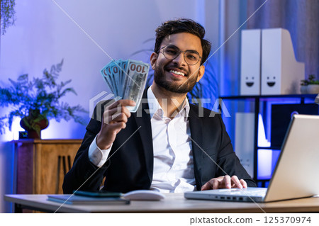 Rich businessman in suit working on laptop pc counting money cash, calculate earnings income profit 125370974