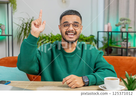 Thoughtful inspired Indian man make Eureka gesture raises finger came up creative plan at home 125371012
