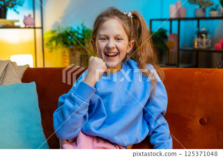 Excited child girl surprised, shocked by sudden victory, good win news, celebrating, wow reaction Excited child girl surprised, shocked by sudden victory, good win news, celebrating, wow reaction 125371048
