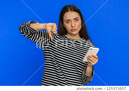 Upset sad woman use smartphone play game, loses, loss fail unlucky news, bad lottery results, crisis 125371057