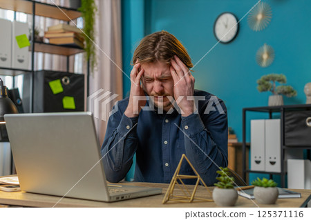 Tired ill businessman suffering from headache problem tension and migraine stress at home office 125371116