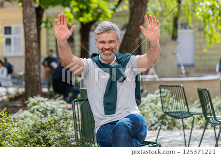 Mature man tourist smiling at camera waving hands gesturing invitation hello hi greeting goodbye 125371221