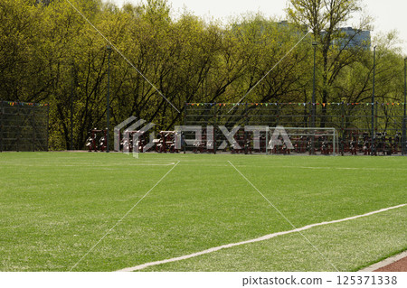 Soccer goal on big field with artificial green grass. Summer season. Outdoor sports activities. Soccer goal on big field with artificial green grass. Summer season. Outdoor sports activities. 125371338