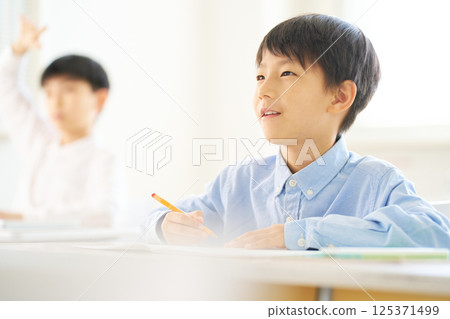 男小學生在教室裡學習 |微笑著展望未來 男小學生在教室裡學習 |微笑著展望未來 125371499