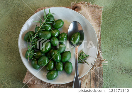 Chalkidiki olives, classic Greek green olive, on a plate, with a spoon, top view, no people, 125371540