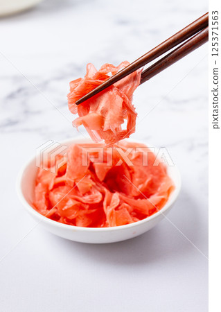 Pickled ginger, with chopsticks, in a small white bowl, on a marble countertop, close-up, no people, 125371563