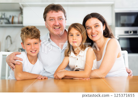 Happy family with two children posing in kitchen Happy family with two children posing in kitchen 125371655