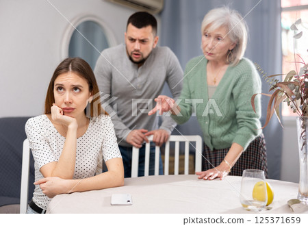 Man and mature woman scolding young woman 125371659