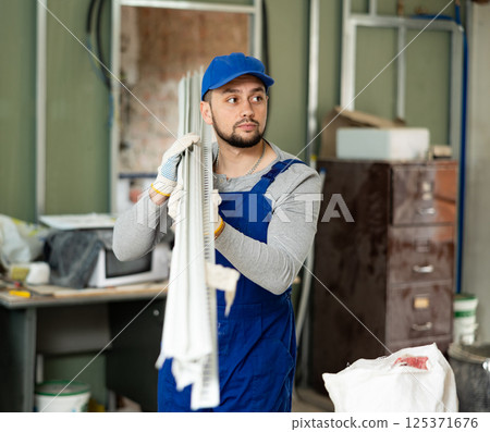 Worker carrying construction materials at renovating object Worker carrying construction materials at renovating object 125371676