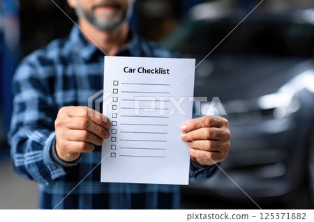 Car Maintenance Checklist Held by Mechanic Car Maintenance Checklist Held by Mechanic 125371882