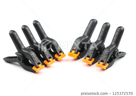 black plastic spring clamp isolated over white background black plastic spring clamp isolated over white background 125372570