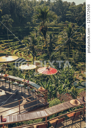 Empty cafe terrace with Balinese umbrellas and view of rice terraces 125372606