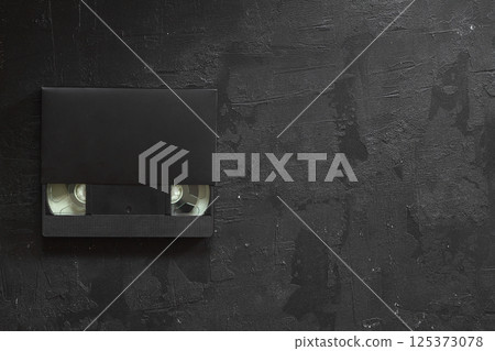 Black VHS video tape cassette with blank label isolated on black background 125373078