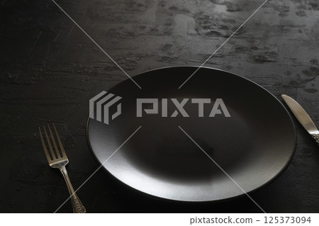 Empty black slate plate on stone table. Flatlay, top view. Mockup for restaurant dish 125373094