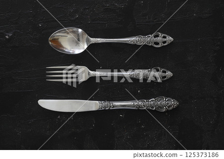 Overhead shot of silverware on black table with copy space. Overhead shot of silverware on black table with copy space. 125373186