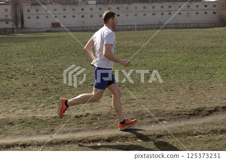 professional runner 40+ years old running outdoors, running concept 125373231