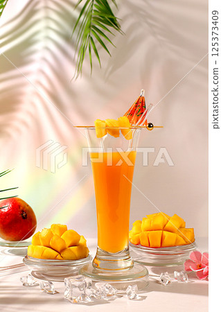 Modern still life with tropical fruits.Homemade cocktail, juice or lemonade with mango slices and ice on sunny kitchen table.Summer party concept and Detox diet, Restaurant menu Modern still life with tropical fruits.Homemade cocktail, juice or lemonade with mango slices and ice on sunny kitchen table.Summer party concept and Detox diet, Restaurant menu 125373409