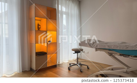 Modern medical Orthopedist's office interior with a comfortable examination table 125373418
