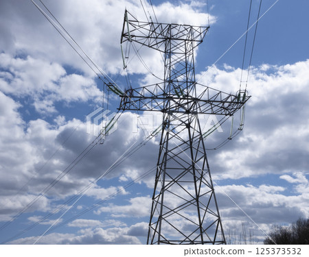 Tower of a high-voltage power line against the of blue sky and clouds 125373532