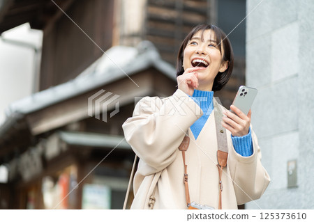 A woman looking at the old-fashioned streetscape; A woman in a coat traveling; Traveling alone A woman looking at the old-fashioned streetscape; A woman in a coat traveling; Traveling alone 125373610
