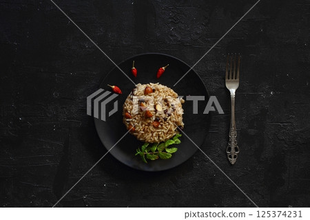 Turkish Stuffed Rice with Currants for Preparing Dolma in Plate with Spoon / Pilav or Pilaf. 125374231