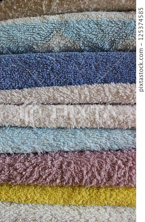 Stack of colorful folded towels closeup stock photo for vertical story Stack of colorful folded towels closeup stock photo for vertical story 125374585