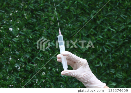 Close up of Hand holding a syringe dropping medicine Close up of Hand holding a syringe dropping medicine 125374609