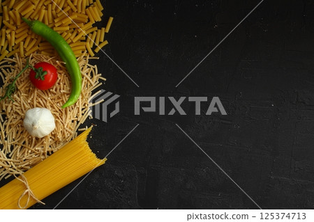 Italian pasta panorama, a flat lay of various sorts of pasta, top shot on a black background Italian pasta panorama, a flat lay of various sorts of pasta, top shot on a black background 125374713