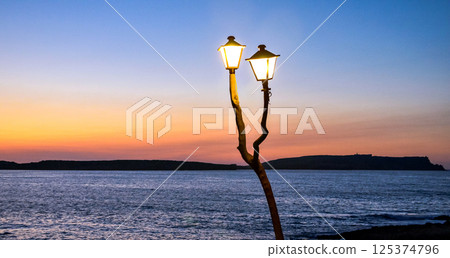 Beautiful views of the sunset to the horizon from a cove in Menorca, Balearic Islands Beautiful views of the sunset to the horizon from a cove in Menorca, Balearic Islands 125374796