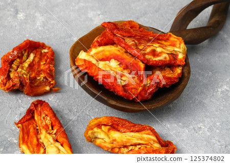 Bowl of sun dried tomatoes on wooden background. Sun dried tomatoes with fresh herbs and spices 125374802