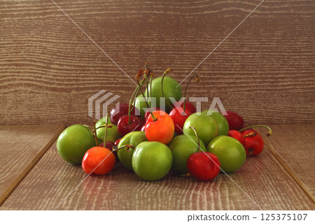 Single whole fresh green Can Erik plum and cherry close up isolated on dark background 125375107