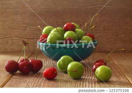 Single whole fresh green Can Erik plum and cherry close up isolated on dark background 125375108
